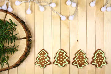 Życzenia świąteczne - tło do życzeń z ręcznie malowanymi piernikami choinkami, drewnianym pniem i lampkami