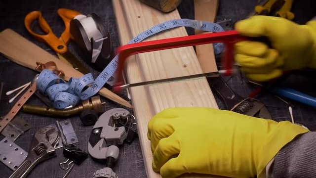 THE WRONG TOOL FOR THE JOB.  #5 IN A SERIES.  ECU SLIDER SHOT OF SOMEONE SAWING LUMBER WITH A SAW USED FOR METAL.  IN 4K.