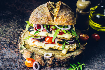 Fresh big ciabatta sandwich stuffed with prosciutto