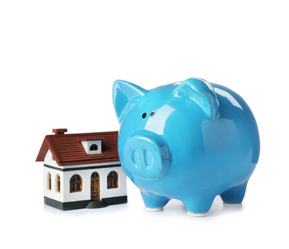 Piggy bank with house model isolated on white