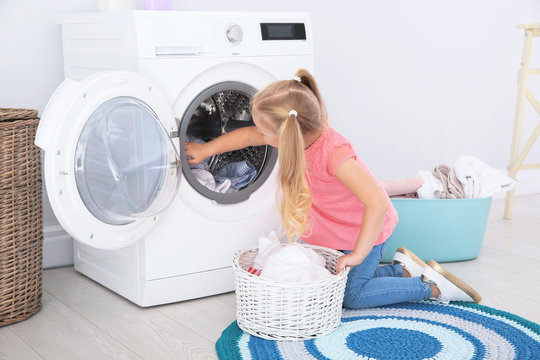 Adorable Little Girl Doing Laundry At Home