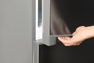 Woman opening refrigerator door, closeup. Space for text
