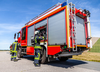 Naklejka premium German fire engine with fireman arround stands on a accident
