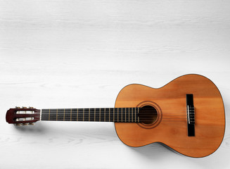 Fototapeta premium Beautiful classical guitar on wooden background, top view