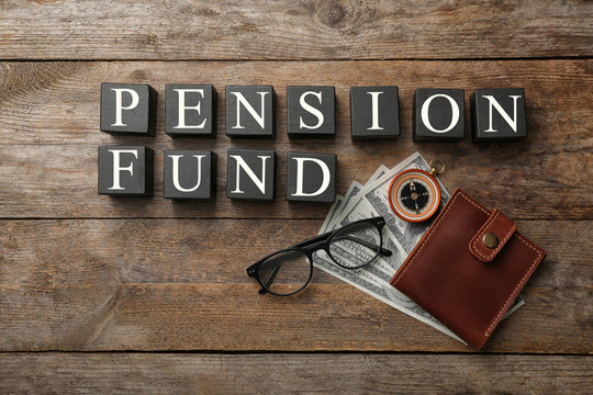Flat lay composition with words PENSION FUND, money and compass on wooden background