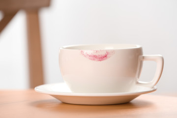 Ceramic cup with lipstick mark on table indoors