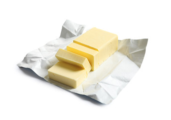 Cut block of fresh butter with wrapper on white background
