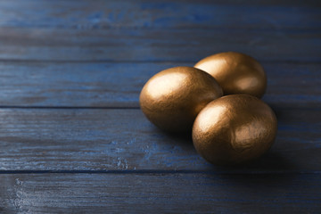 Golden eggs and space for text on wooden background. Pension concept