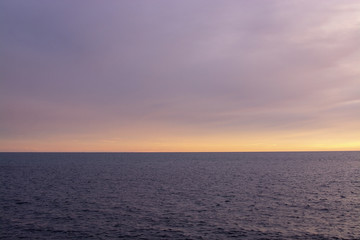 Straight horizon line over Mediterranean sea in pink and blue