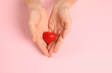 Woman holding decorative heart on color background, top view with space for text