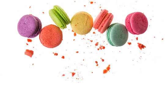 Flat lay, top view. French macaroons isolated on white background. Cookies falls mixed with crumbs. Copy space.