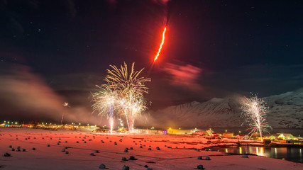 New years fireworks over town of Hauganes, Iceland