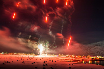New years fireworks over town of Hauganes, Iceland