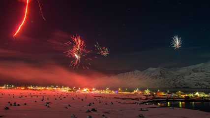 New years fireworks over town of Hauganes, Iceland