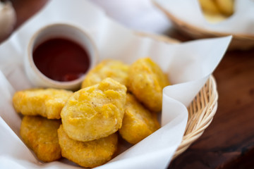 Fried chicken nugget serve with ketchup tomato sauce in basket.
