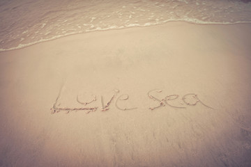 Fototapeta na wymiar the beach sea texture text on sand beach written words Love sea on sand