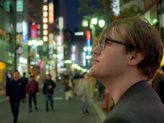 A young man exploring the neon lights of a big Asian city