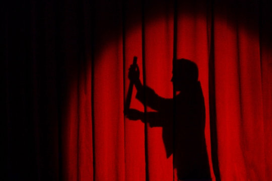 Magician silhouette isolated on the red background