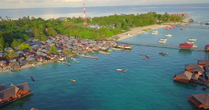 Aerial flight towards the beach and over floating resort in Mabul, Malaysia