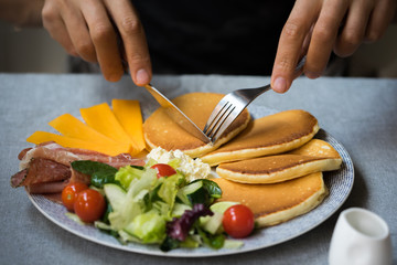 original pancakes breakfast set on the table with hands