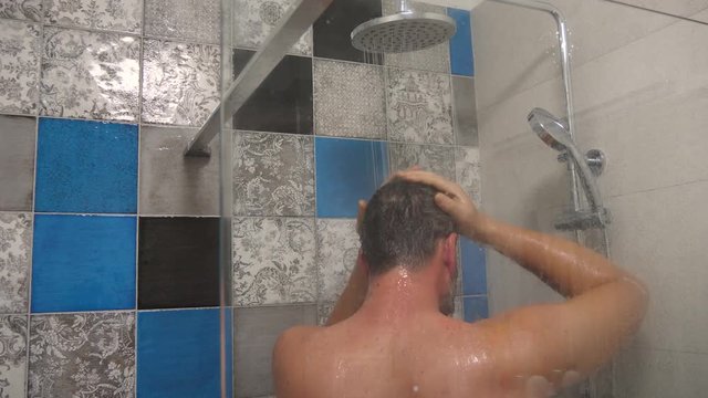 Close up footage of man taking shower at hom in his shower.