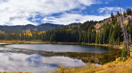 Silver Lake by Solitude and Brighton Ski resort in Big Cottonwood Canyon. Panoramic Views from the hiking and boardwalk trails of the surrounding mountains, aspen and pine trees in brilliant fall autu © Jeremy