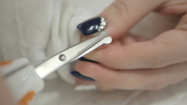 Mother cutting newborn baby's nails