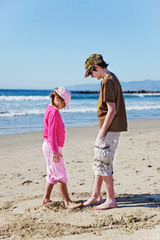 Brother & sister's impromptu sand game at the beach