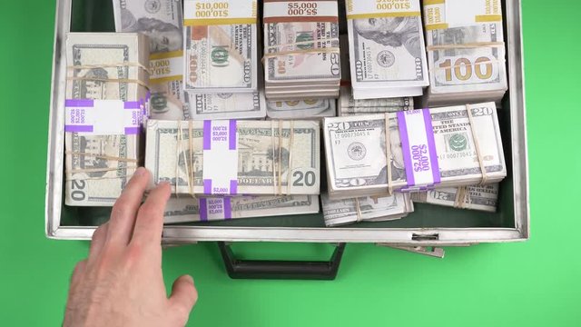 Opening a briefcase filled with money inside. Top view from above. Green screen table. Chroma key