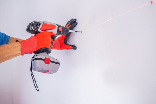 Man twists a screw into the wall