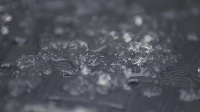 macro shot of snow melting in the sun in accelerated video with a nice grey background