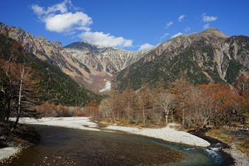 Fototapeta na wymiar Beautiful crystal clear water river landscape with mountain background in Japan Alps Kamikochi, Nagano, Japan in November