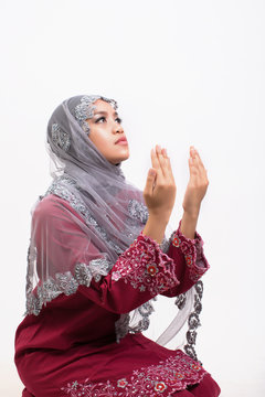 Young asian women muslim wearing red jijab praying isolate on white background