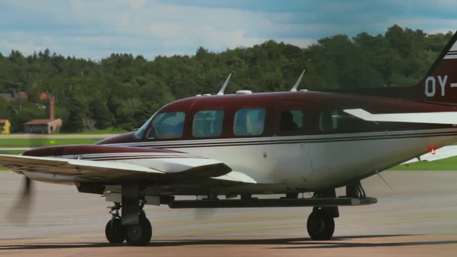 Piper Turboprop Twin Engine Aircraft Taxiing for Take Off. Shot Tracking the Movement of the Plane on the Small Local Airfield. Air Traffic Control Tower in the Background.