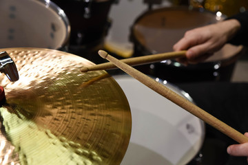 Obraz premium Professional drum set closeup. Man drummer with drumsticks playing drums and cymbals, on the live music rock concert or in recording studio 