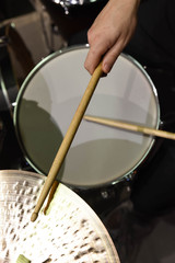  Professional drum set closeup. Man drummer with drumsticks playing drums and cymbals, on the live music rock concert or in recording studio   