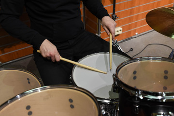  Professional drum set closeup. Man drummer with drumsticks playing drums and cymbals, on the live music rock concert or in recording studio   