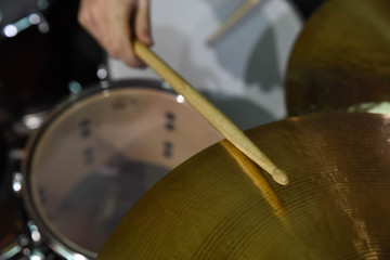  Professional drum set closeup. Man drummer with drumsticks playing drums and cymbals, on the live...