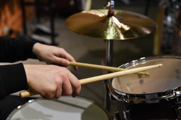  Professional drum set closeup. Man drummer with drumsticks playing drums and cymbals, on the live music rock concert or in recording studio   