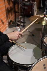 Professional drum set closeup. Man drummer with drumsticks playing drums and cymbals, on the live...