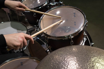 Plakat Professional drum set closeup. Man drummer with drumsticks playing drums and cymbals, on the live music rock concert or in recording studio 