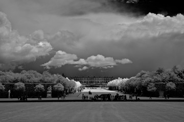 Infrared black and white image of Château Versailles with storm clouds and spot of sun peaking...