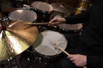 Obraz premium Professional drum set closeup. Man drummer with drumsticks playing drums and cymbals, on the live music rock concert or in recording studio 