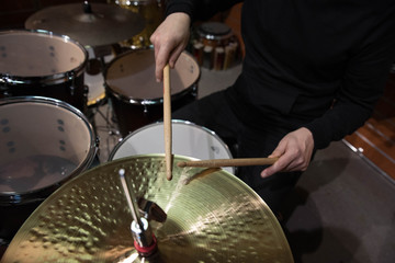 Professional drum set closeup. Man drummer with drumsticks playing drums and cymbals, on the live...