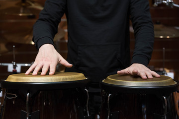 Professional percussion drum set closeup. Man drummer playing kongo percussion drums on the live music rock concert or in recording studio   