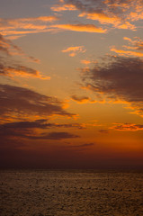 Amazing sea sunset on the pebble beach, the sun, waves, clouds