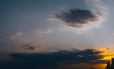 Landscape with dramatic light - beautiful golden sunset with saturated sky and clouds.