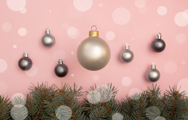 Pearl Christmas balls on the pink background with pine tree branches