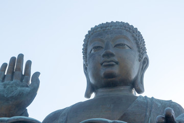 Fototapeta premium Closeup horizontal photo of Tian Tan Buddha, Lantau Island, Hong Kong. copy space in sky above buddha.