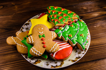 Plate with different christmas gingerbread cookies on wooden table